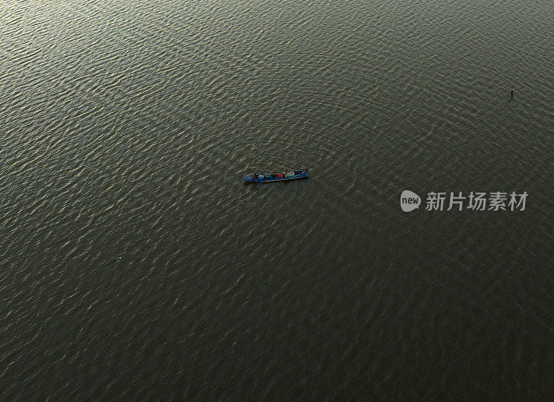 在一个阳光明媚的下午，一艘小船在金毛省的Thi Tuong泻湖上航行